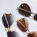 Folded aviator sunglasses with gold metal frames and tinted lenses