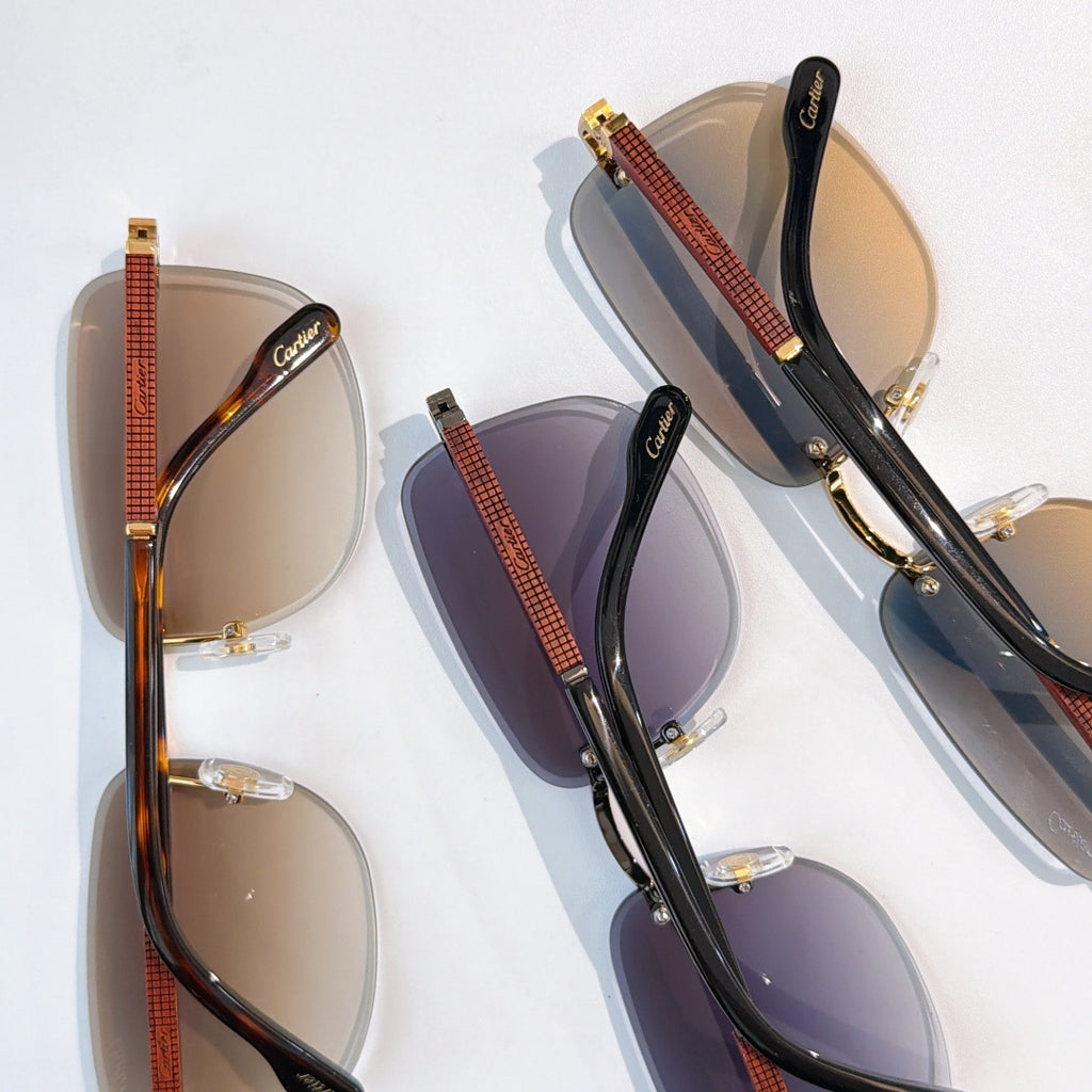 Cartier glasses set with dark lenses and gold hardware, black frames with red-brown temples