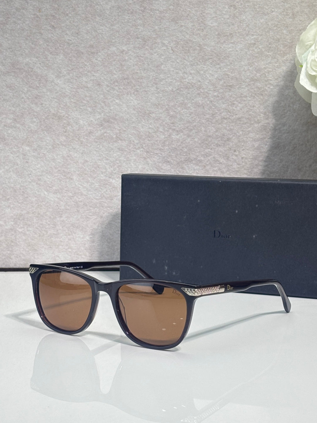 Dior sunglasses with dark frame and brown tinted lenses, three-quarter angle
