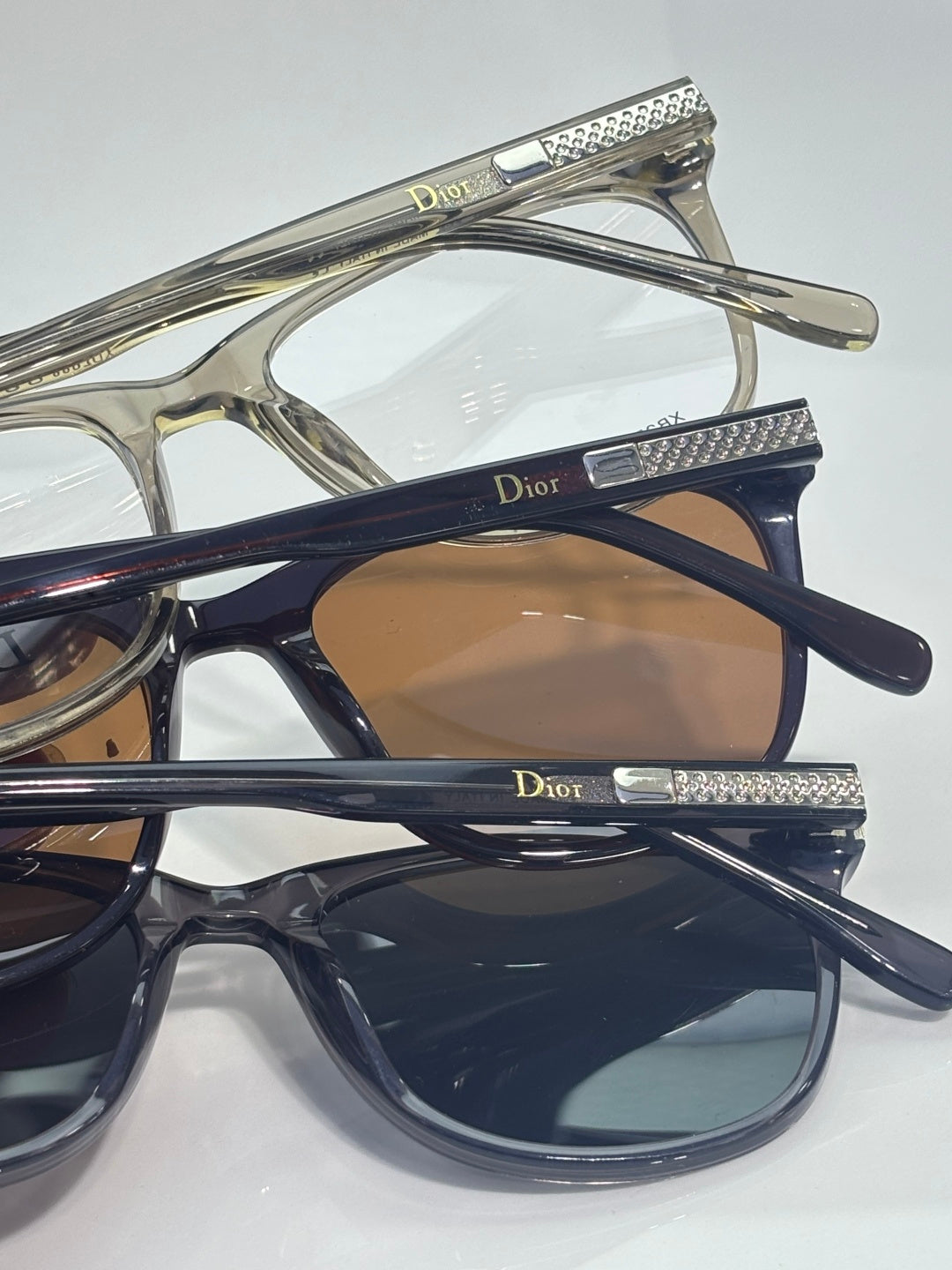 Dior eyeglasses set with gold and dark blue frames and tinted lenses, stacked