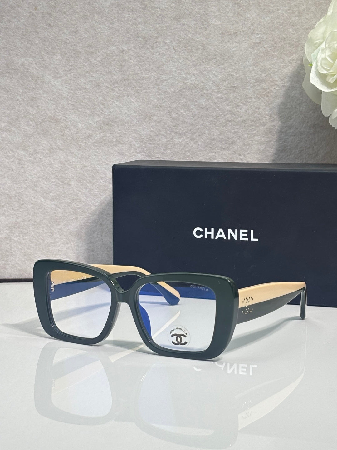 Chanel glasses with dark blue frames and clear lenses, gold-tone temple arms