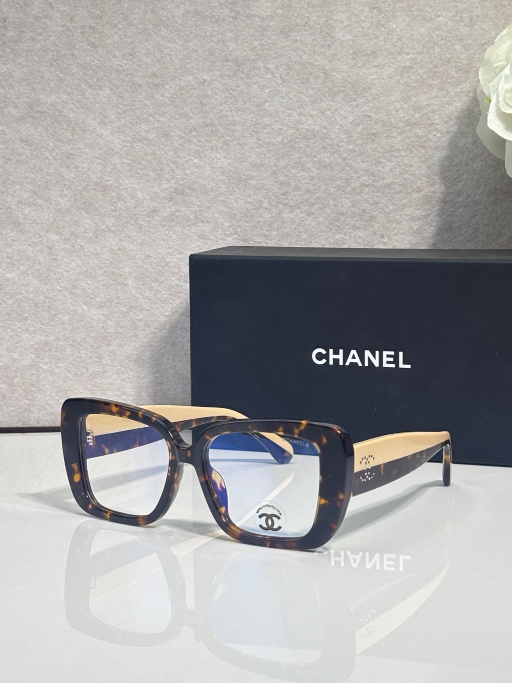 Chanel glasses with dark blue and brown frames, clear lenses, gold-tone arms