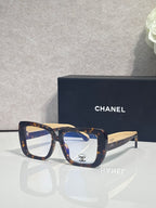 Chanel glasses with dark blue and brown frames, clear lenses, gold-tone arms