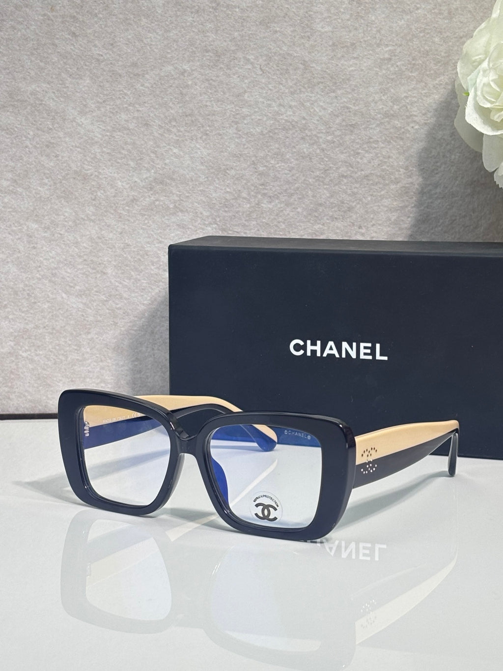 Chanel glasses with dark blue frames and clear lenses, gold-tone temple arms