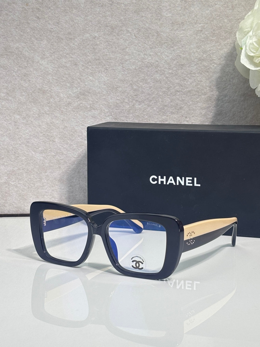 Chanel glasses with dark blue frames and clear lenses, gold-tone temple arms