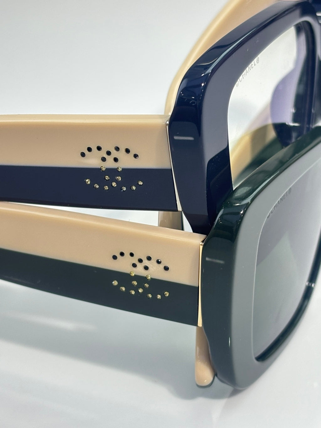 Chanel glasses close-up of dark frame temples with gold-tone stud details and logo