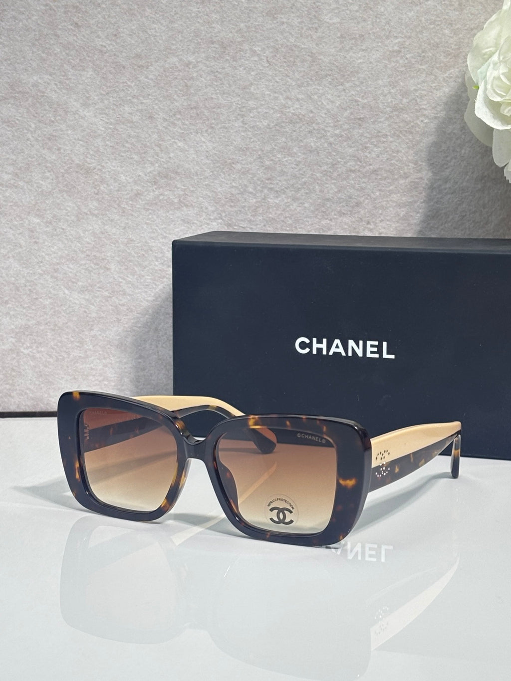 Chanel glasses with dark blue frames and gold-tone temples, square lens profile view