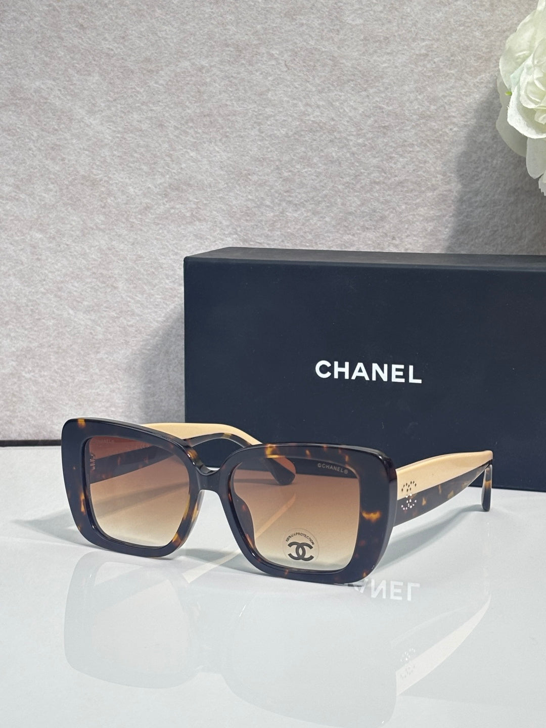 Chanel glasses with dark blue frames and gold-tone temples, square lens profile view