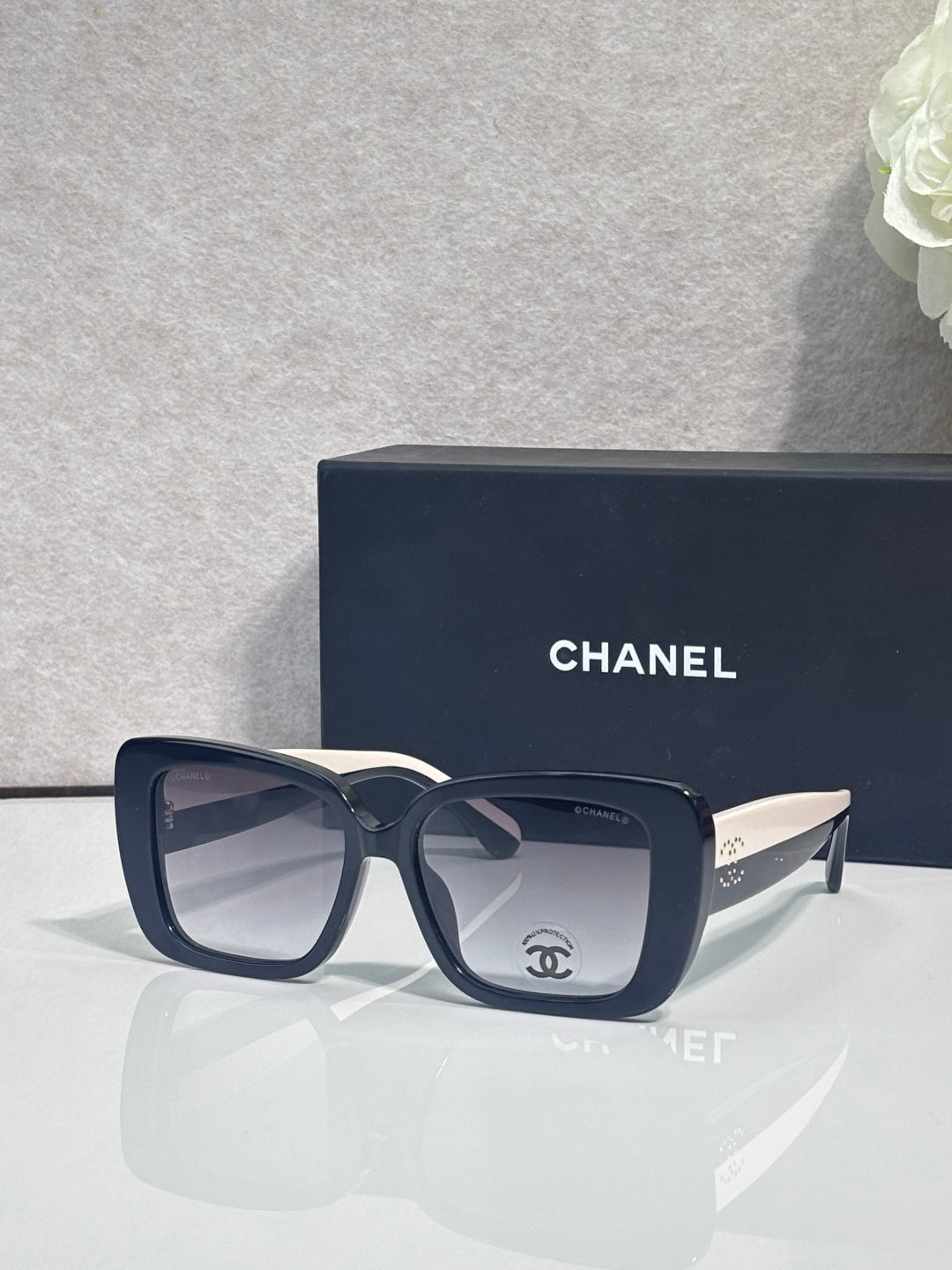 Chanel glasses with dark blue frames and mirrored-square lenses, gold-tone temple accents