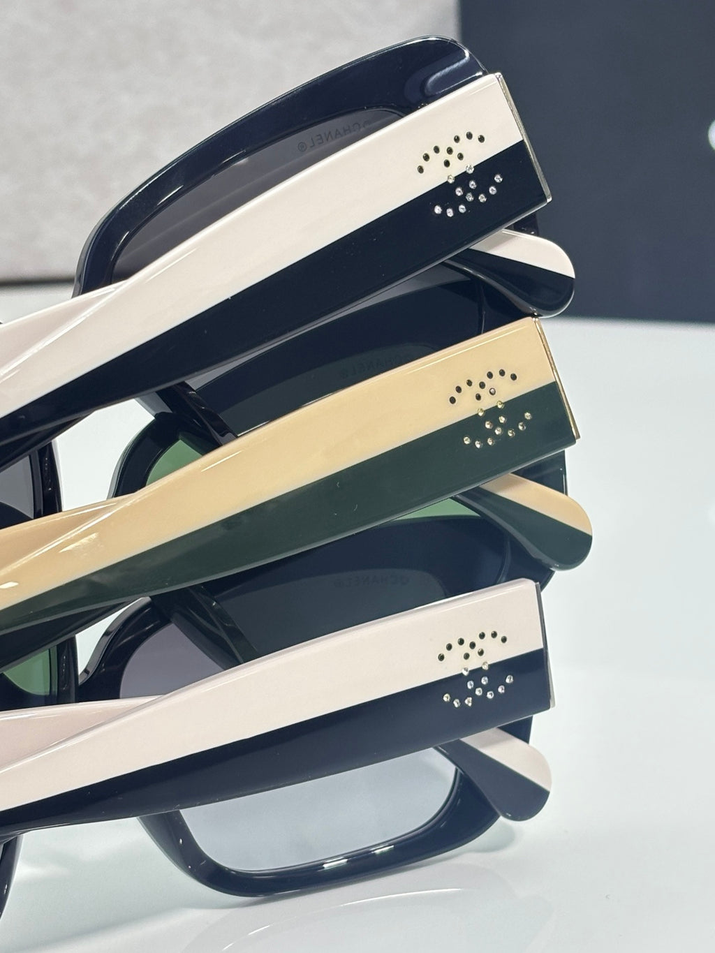 Chanel glasses close-up of cream and dark temple bands with studded logo accents