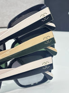 Chanel glasses close-up of cream and dark temple bands with studded logo accents