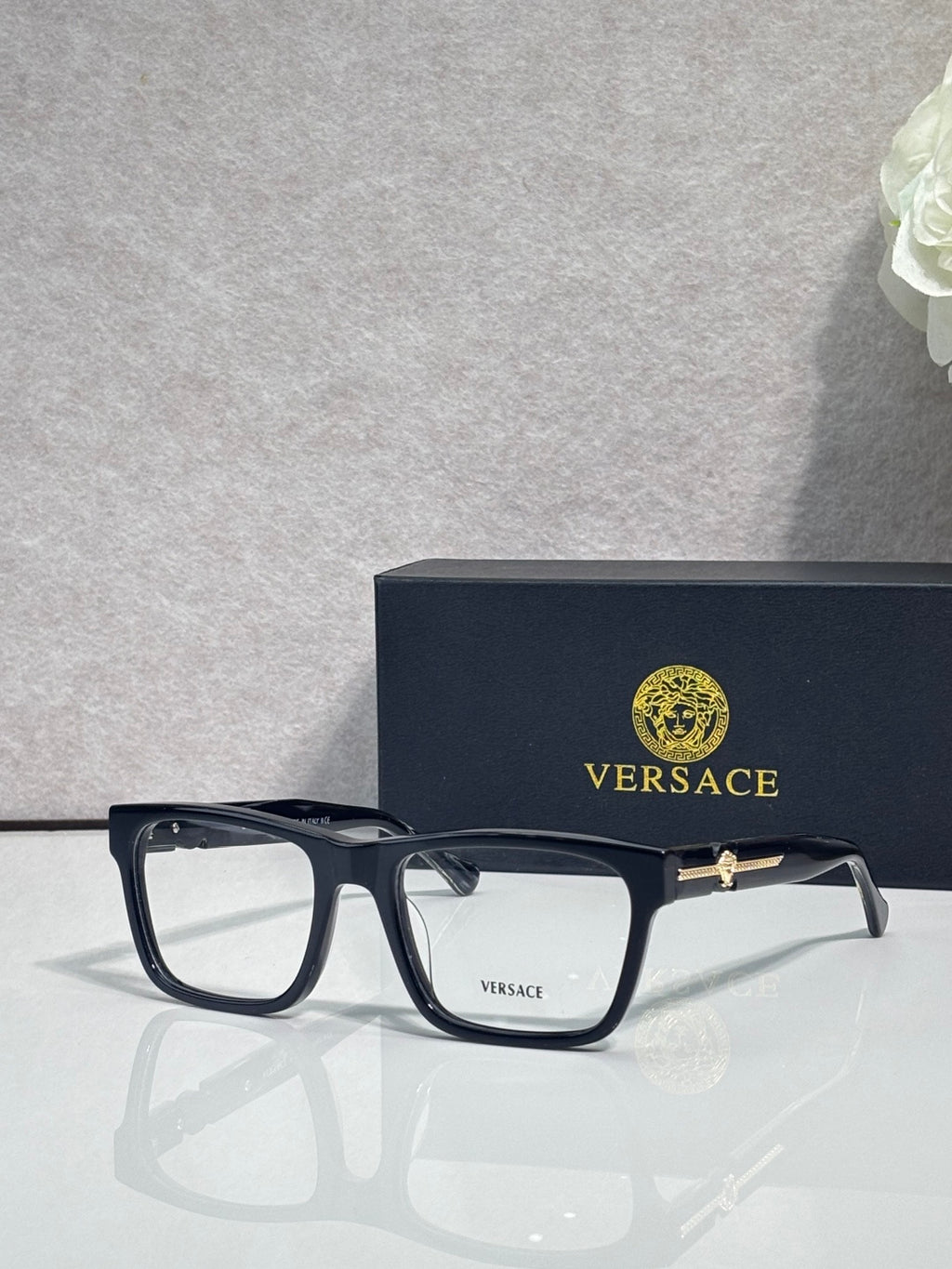Versace eyeglasses with dark acetate frame, clear lenses, and gold bridge logo