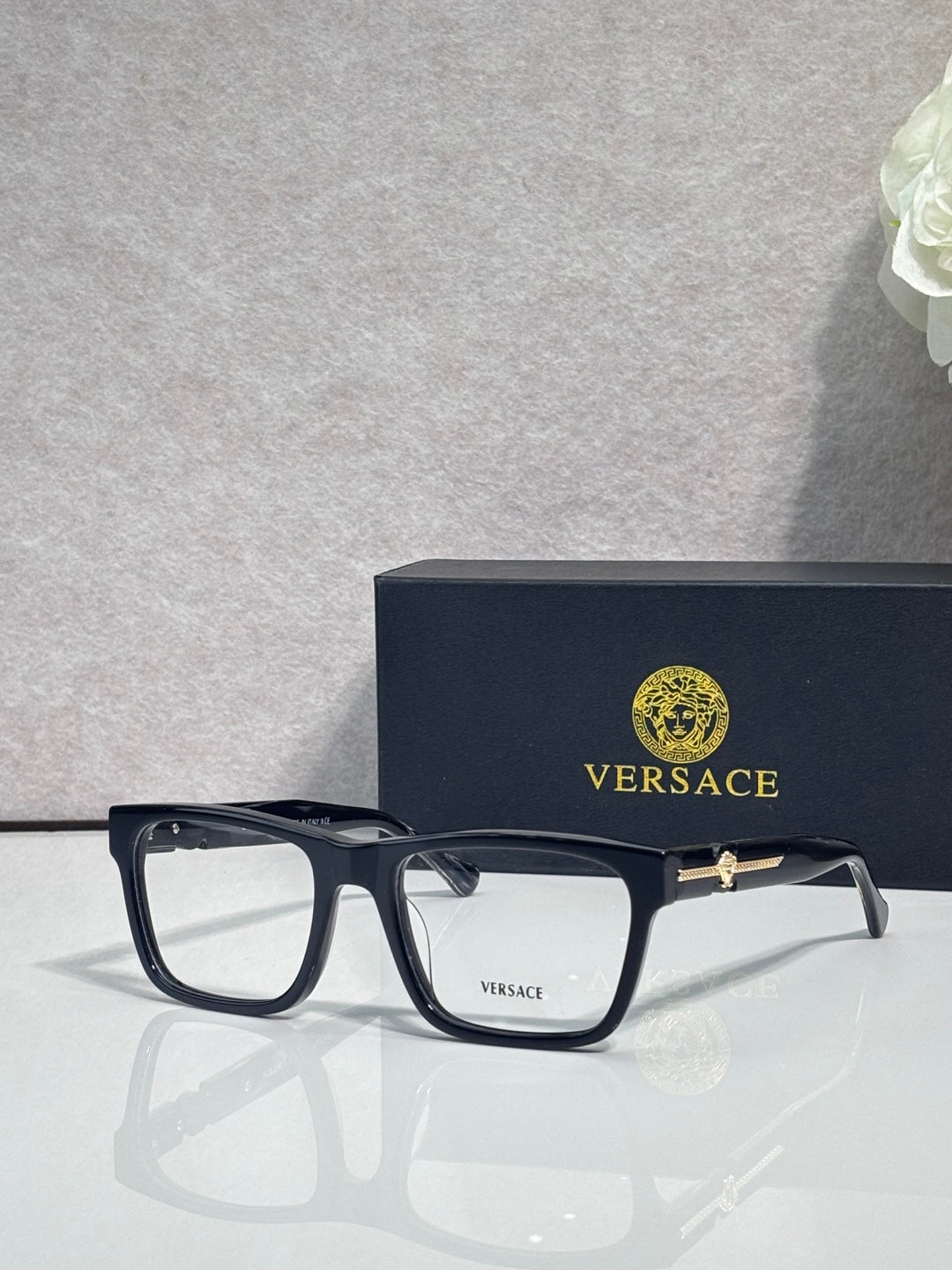 Versace eyeglasses with dark acetate frame, clear lenses, and gold bridge logo