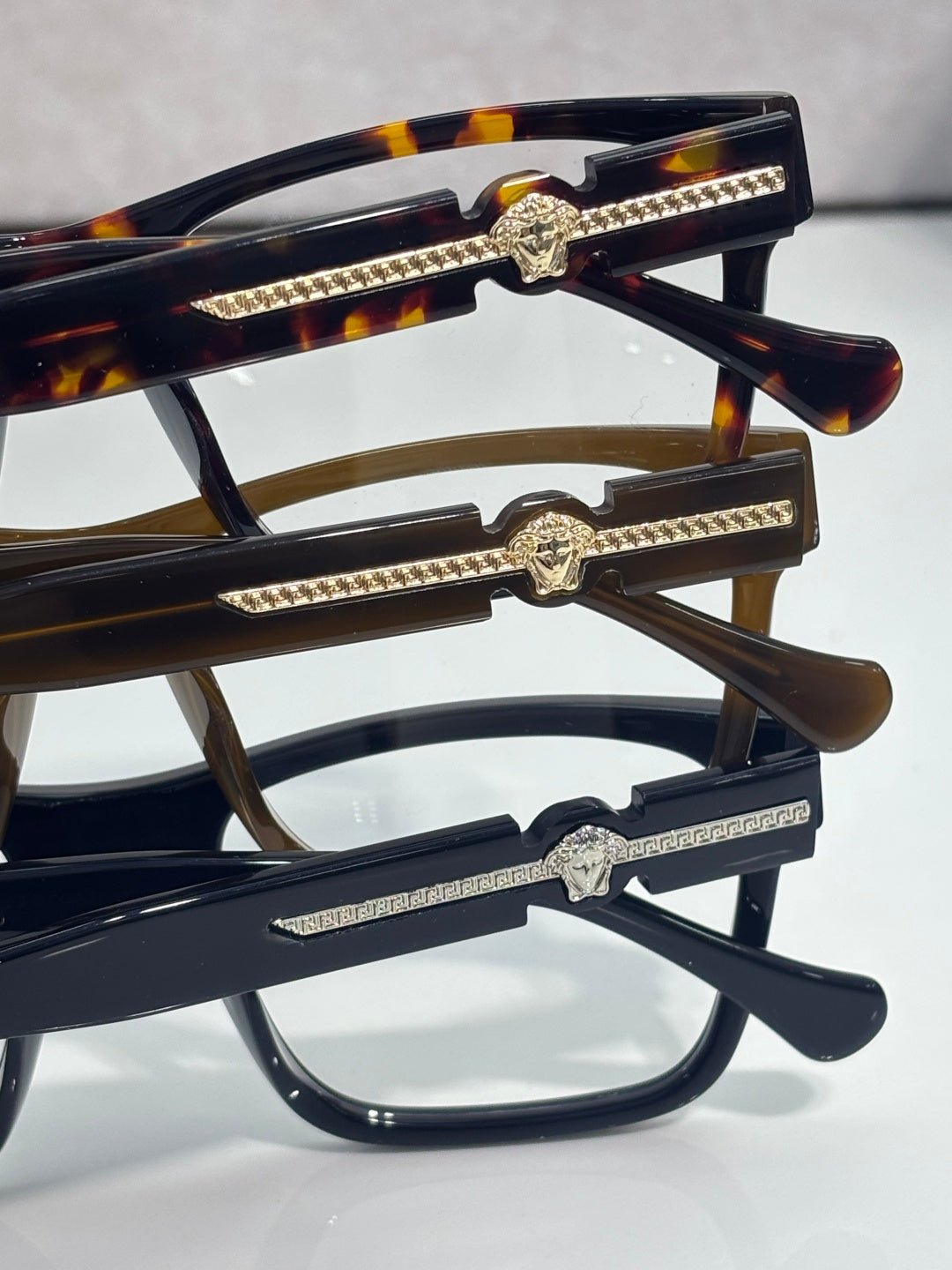 Versace eyeglass temples with gold rhinestone bars and Medusa emblem, dark acetate