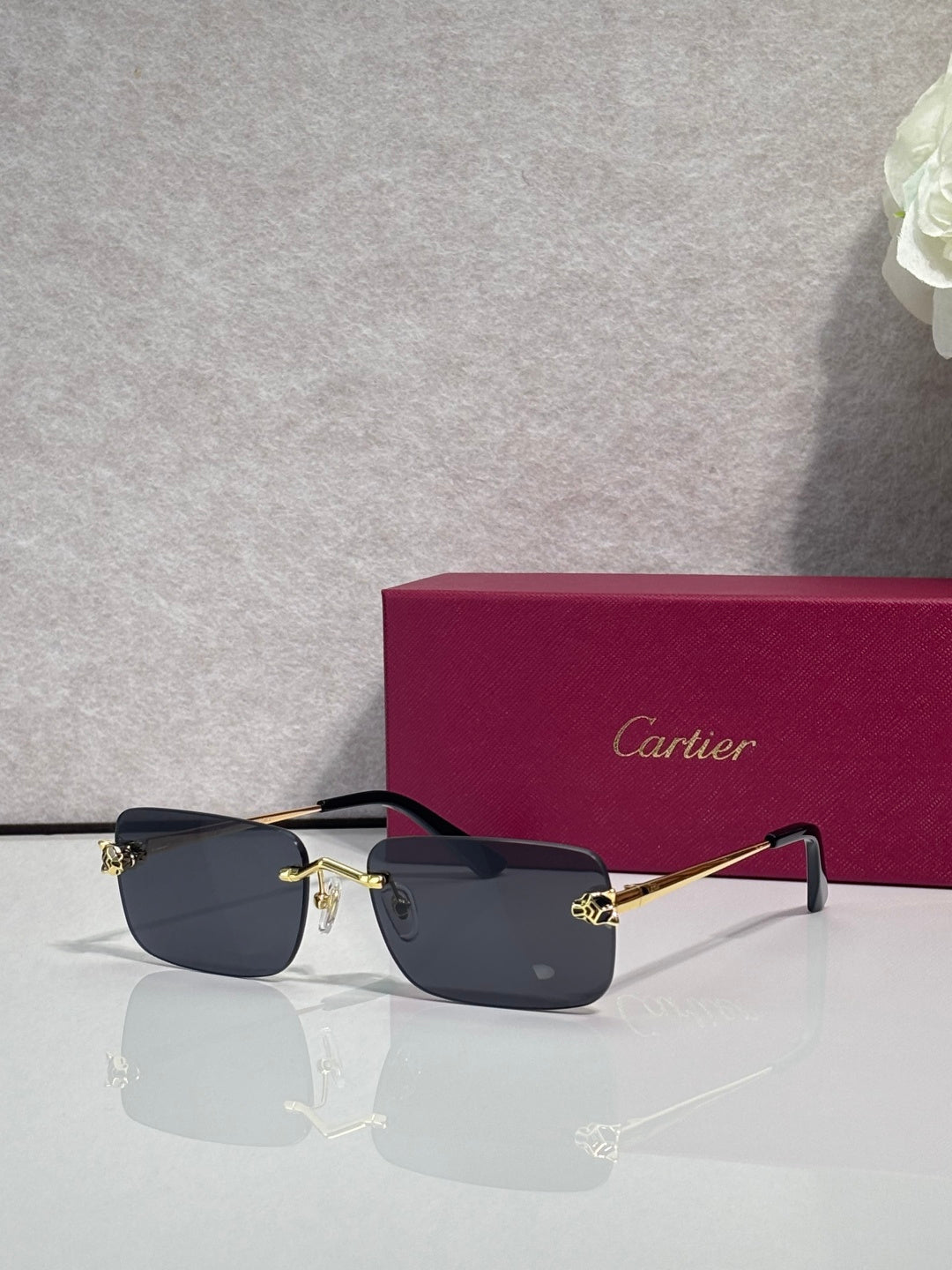 Rectangular eyeglasses with gold frame, dark blue lenses, and black temple arms
