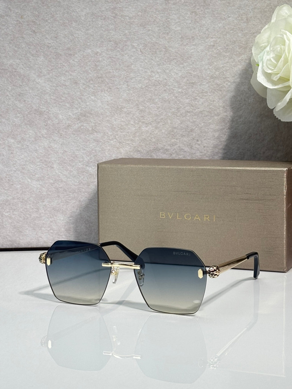 Square dark gradient sunglasses with black frame and gold hinge details