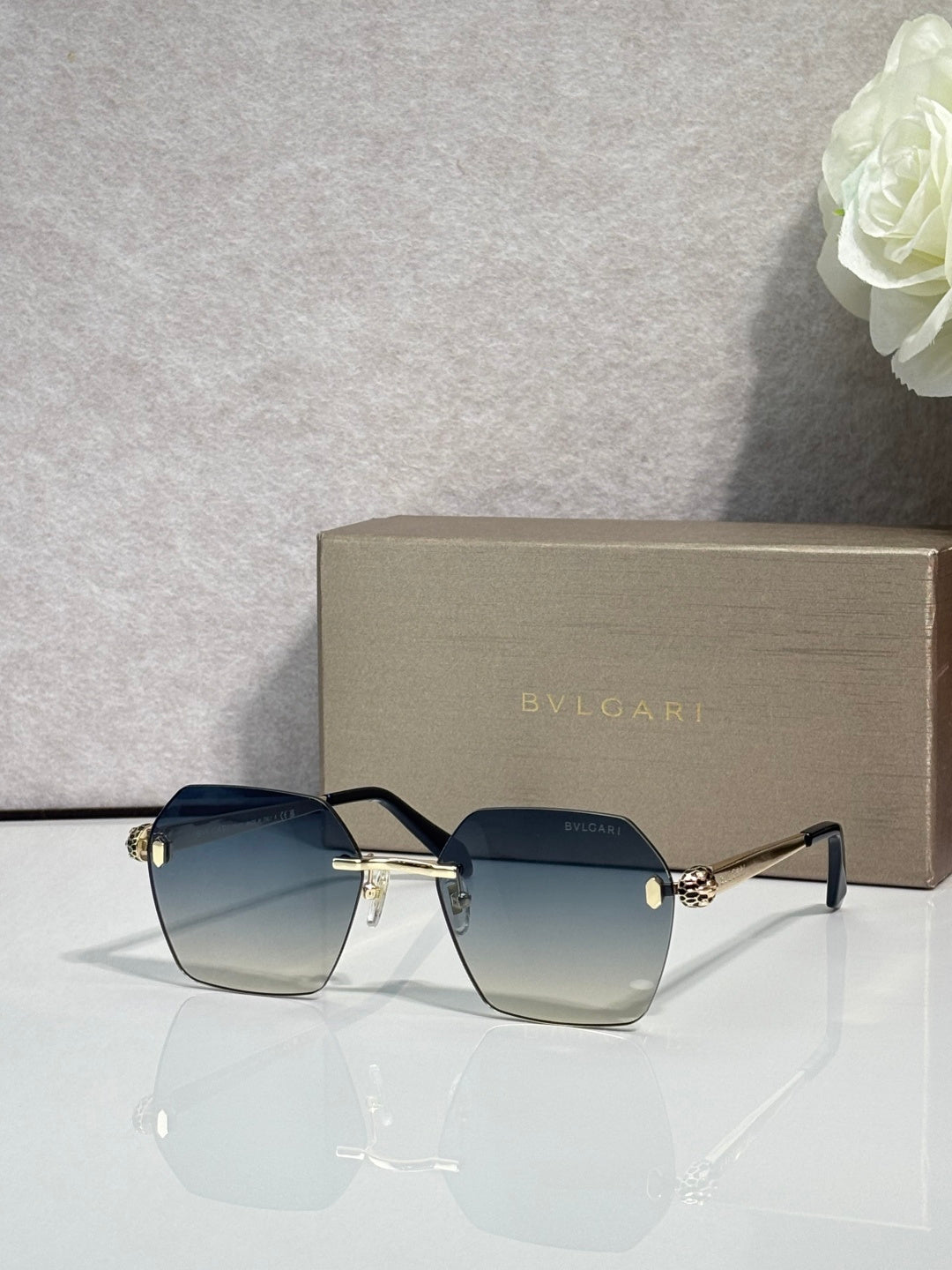 Square dark gradient sunglasses with black frame and gold hinge details