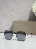 Square dark sunglasses with black frame and gold logo detail across bridge