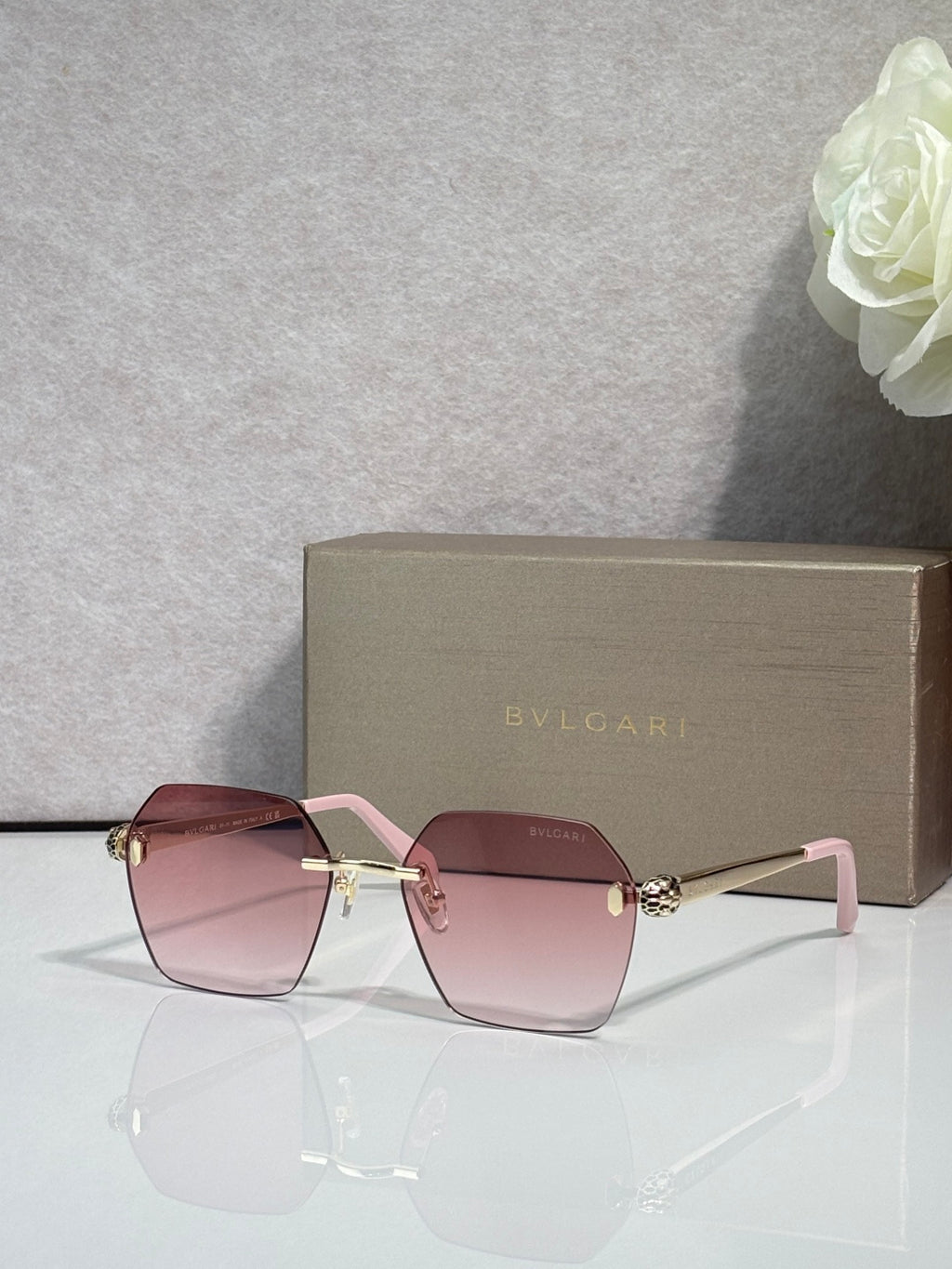 Square pink sunglasses with light pink frame accents and gold bridge detail