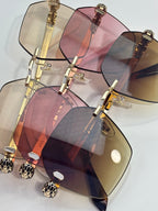Stacked multi-color sunglasses with gold frames, pink and amber gradient lenses