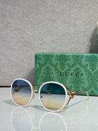 Round sunglasses with light lenses; silver-tone frame and blue outer rims.
