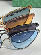 Gucci sunglasses close-up: gold-tone frames with tinted lenses and pearl chain