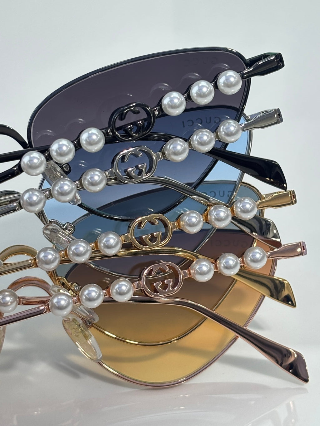 Gucci sunglasses close-up: pearl-beaded chain detail on tinted lenses