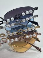 Gucci sunglasses close-up: pearl-beaded chain detail on tinted lenses