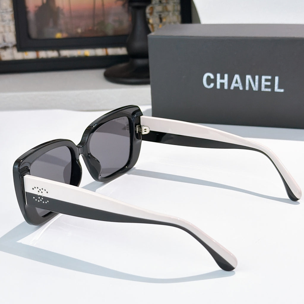 Chanel sunglasses side view with black frame, dark lenses, and pale arm accents