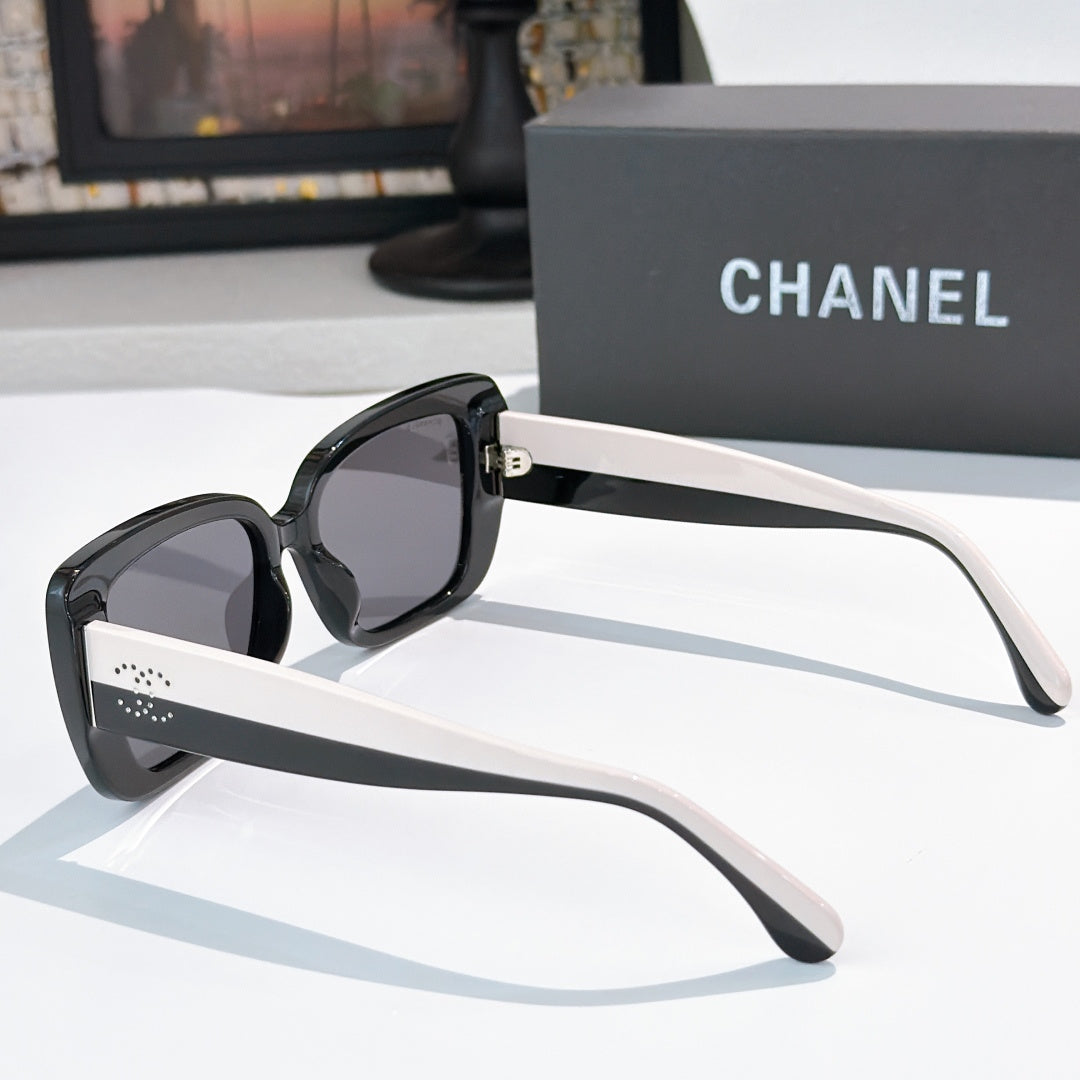 Chanel sunglasses side view with black frame, dark lenses, and pale arm accents