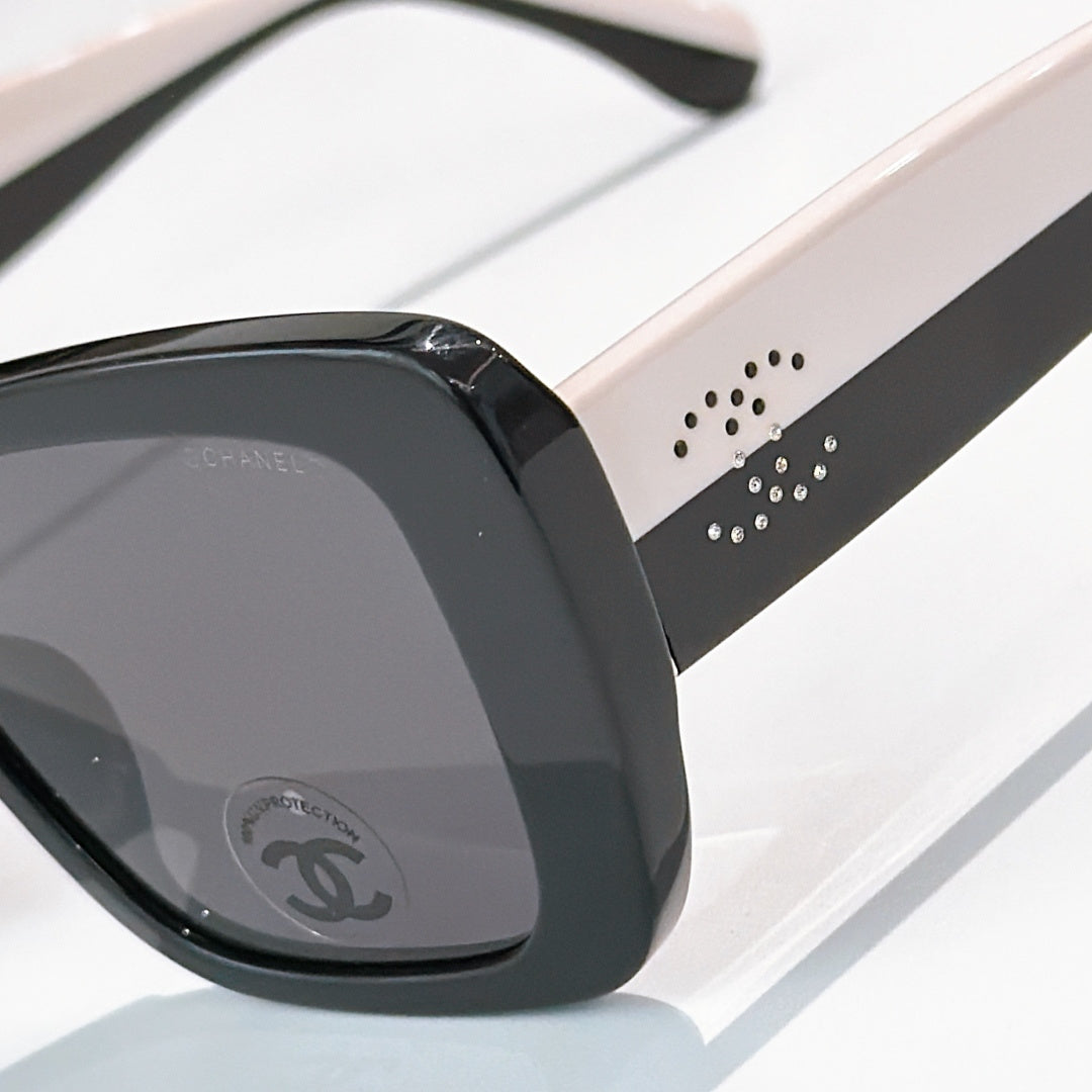 Chanel sunglasses close-up: black frame with studded arm detail and dark lenses