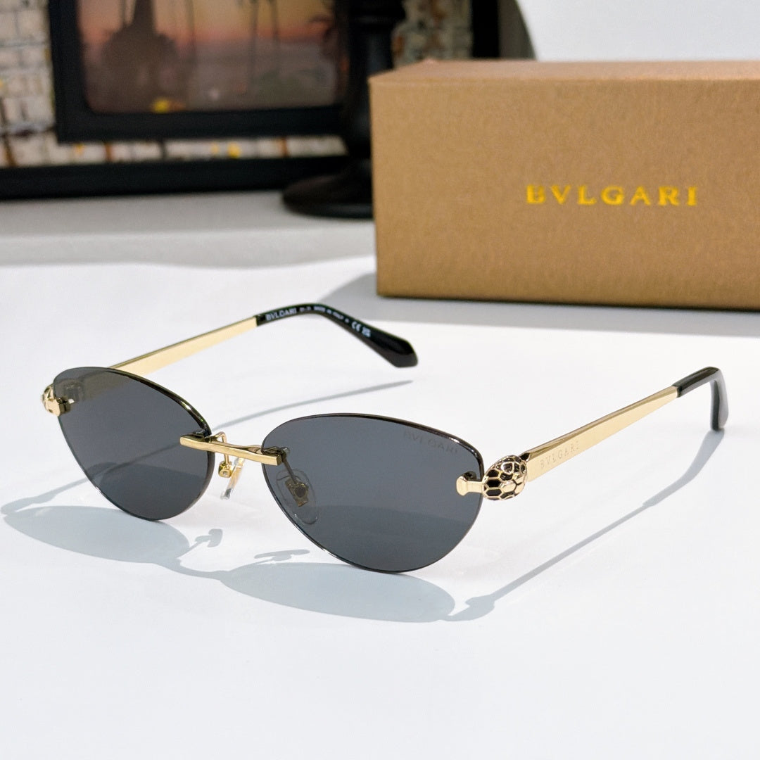 Gold oval sunglasses with gray-blue lenses and jeweled bridge