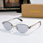Gold oval sunglasses with light-blue lenses and jeweled bridge
