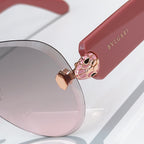 Bvlgari sunglasses close-up: pink cat-eye lenses, gold hinge, and pink temple.