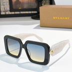 Square sunglasses, dark frames with blue gradient lenses, gold logo on temples
