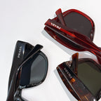 Stacked Prada sunglasses, red and dark frames with tinted lenses