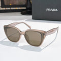 Sunglasses by Prada, light pink frame with brown-tinted lenses
