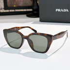 Sunglasses by Prada, tortoiseshell frame with gray-green tinted lenses
