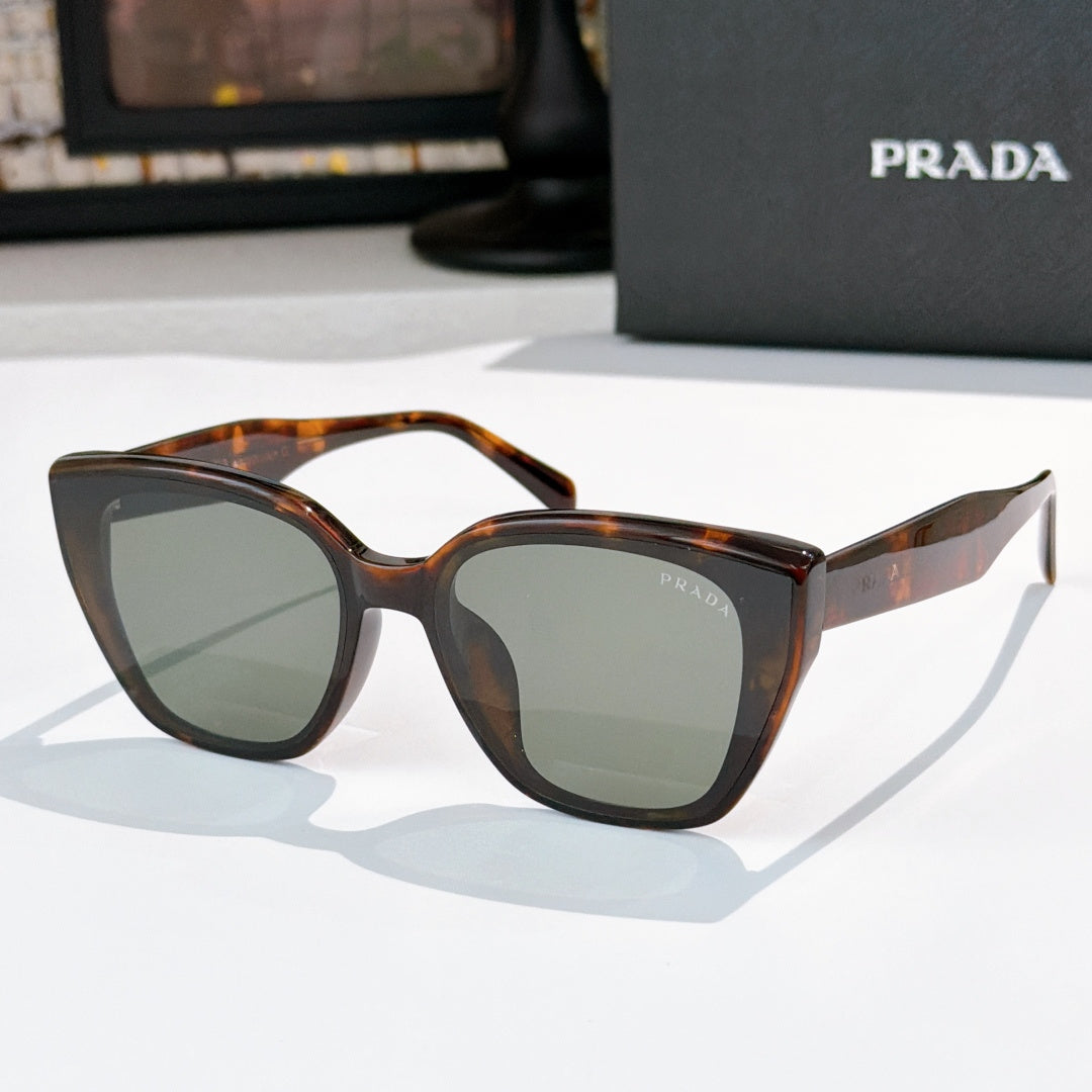Sunglasses by Prada, tortoiseshell frame with gray-green tinted lenses