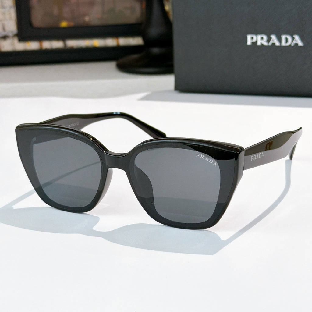 Sunglasses by Prada, black frame with dark tinted lenses