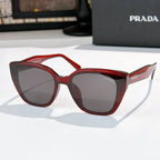 Sunglasses by Prada, red frame with dark tinted lenses