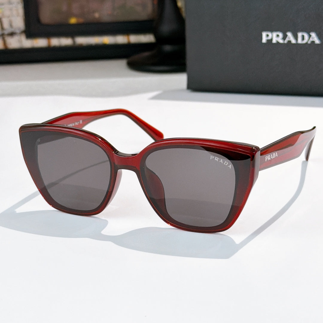 Sunglasses by Prada, red frame with dark tinted lenses