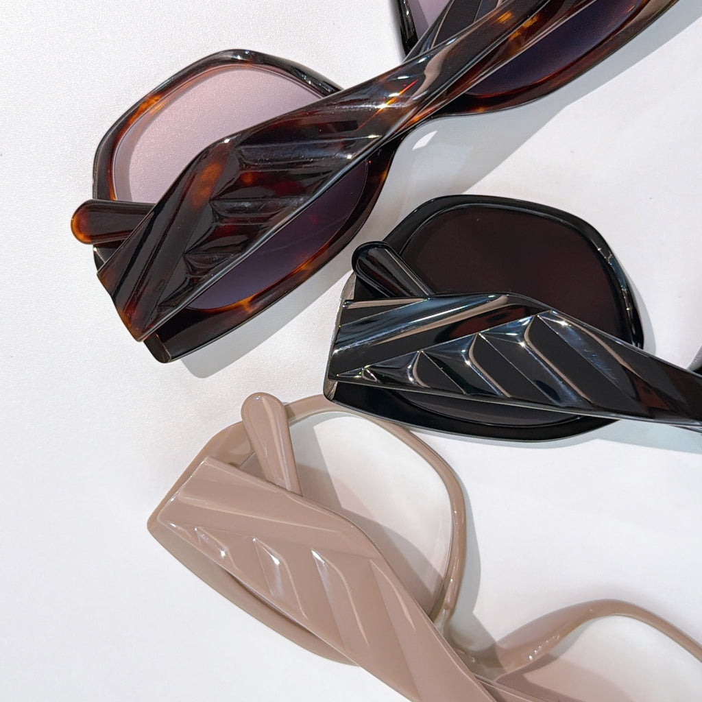 Prada assortment of cat-eye sunglasses frames in dark, tortoise, and light colors