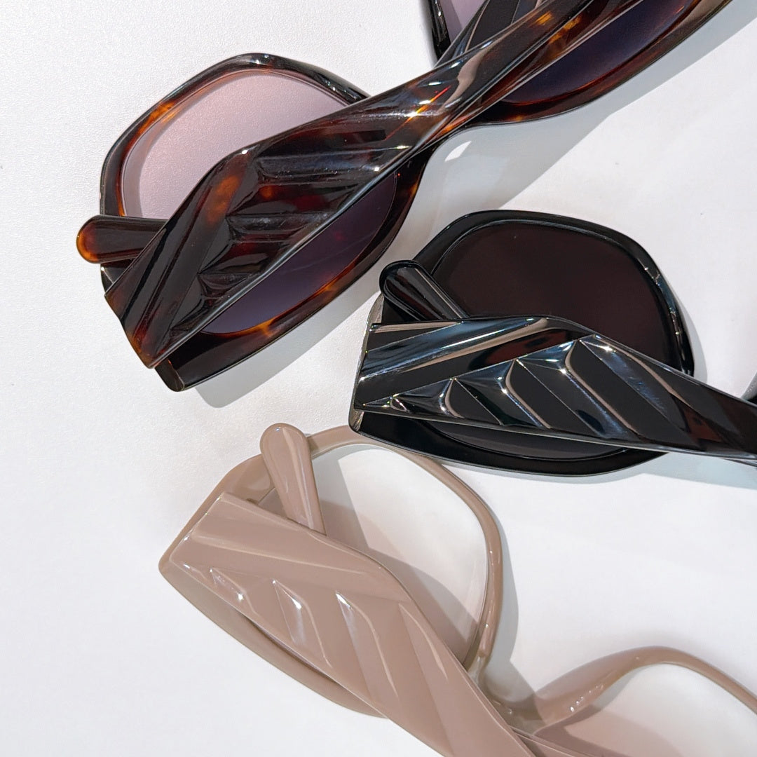 Prada assortment of cat-eye sunglasses frames in dark, tortoise, and light colors
