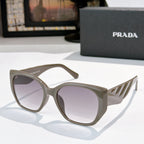Prada cat-eye sunglasses with dark lenses and olive-tinted translucent frames