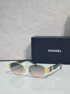CHANEL sunglasses with gold frame, green temples, tinted rose lenses.