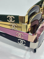 CHANEL sunglasses with gold frames and dark lenses; CC logo on case lids.