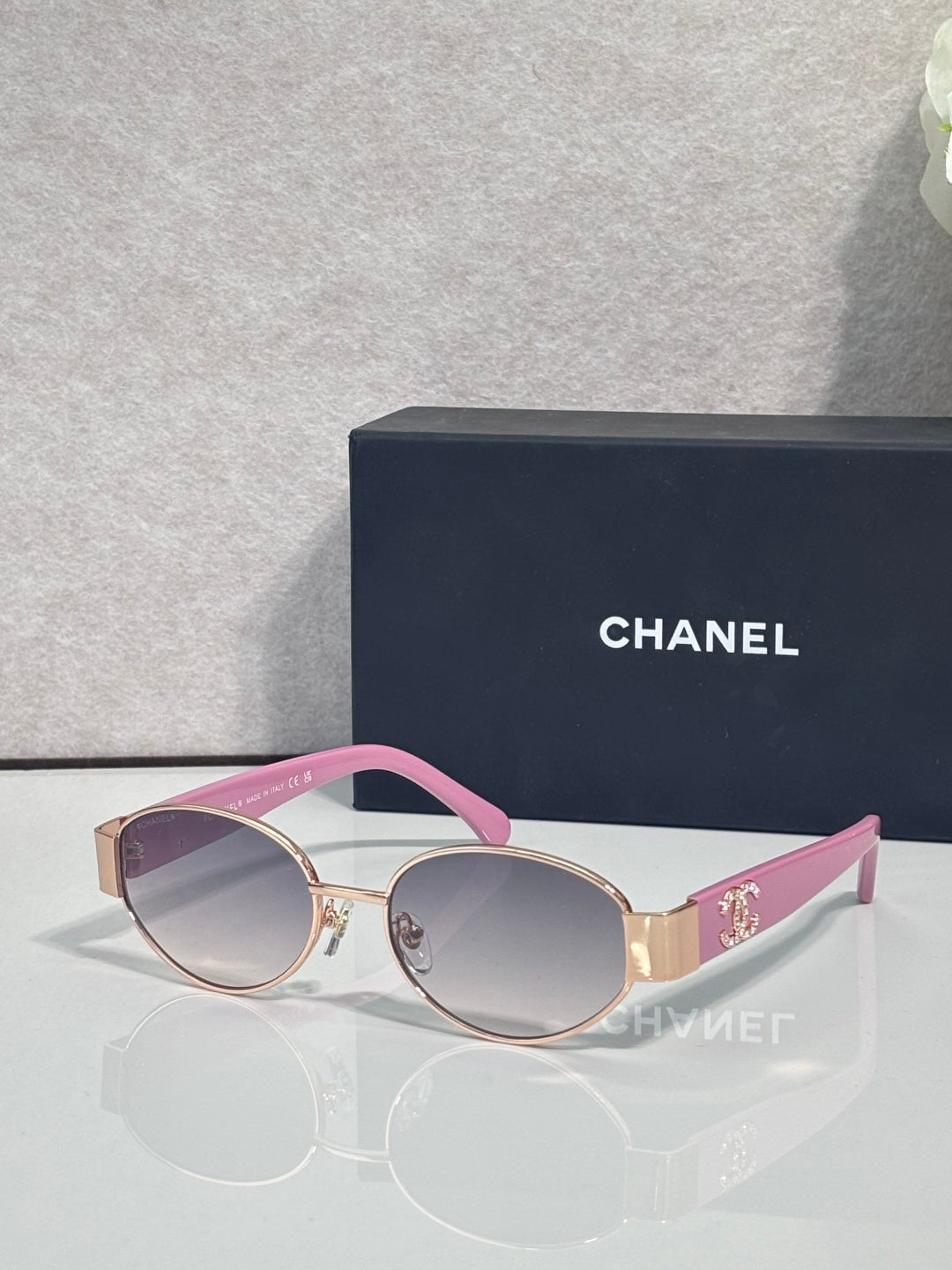 CHANEL sunglasses with gold frame, pink temples, tinted rose lenses.