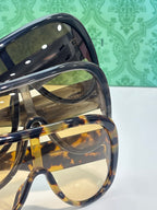 Gucci oversized sunglasses close-up with dark frame and reflective tinted lenses