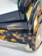 Gucci sunglasses temple and side close-up with tortoiseshell pattern and logo